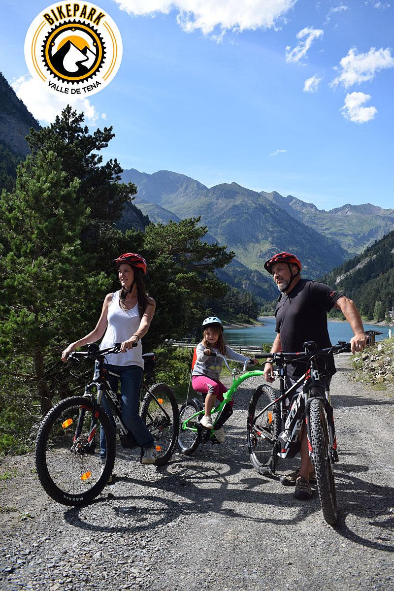 Familia en bicicleta junto al embalse